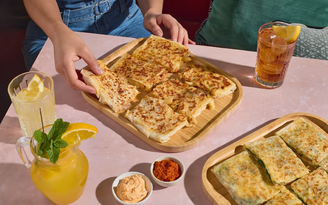 Vers gebakken gözleme op houten planken, met huisgemaakte limonade en ijsthee