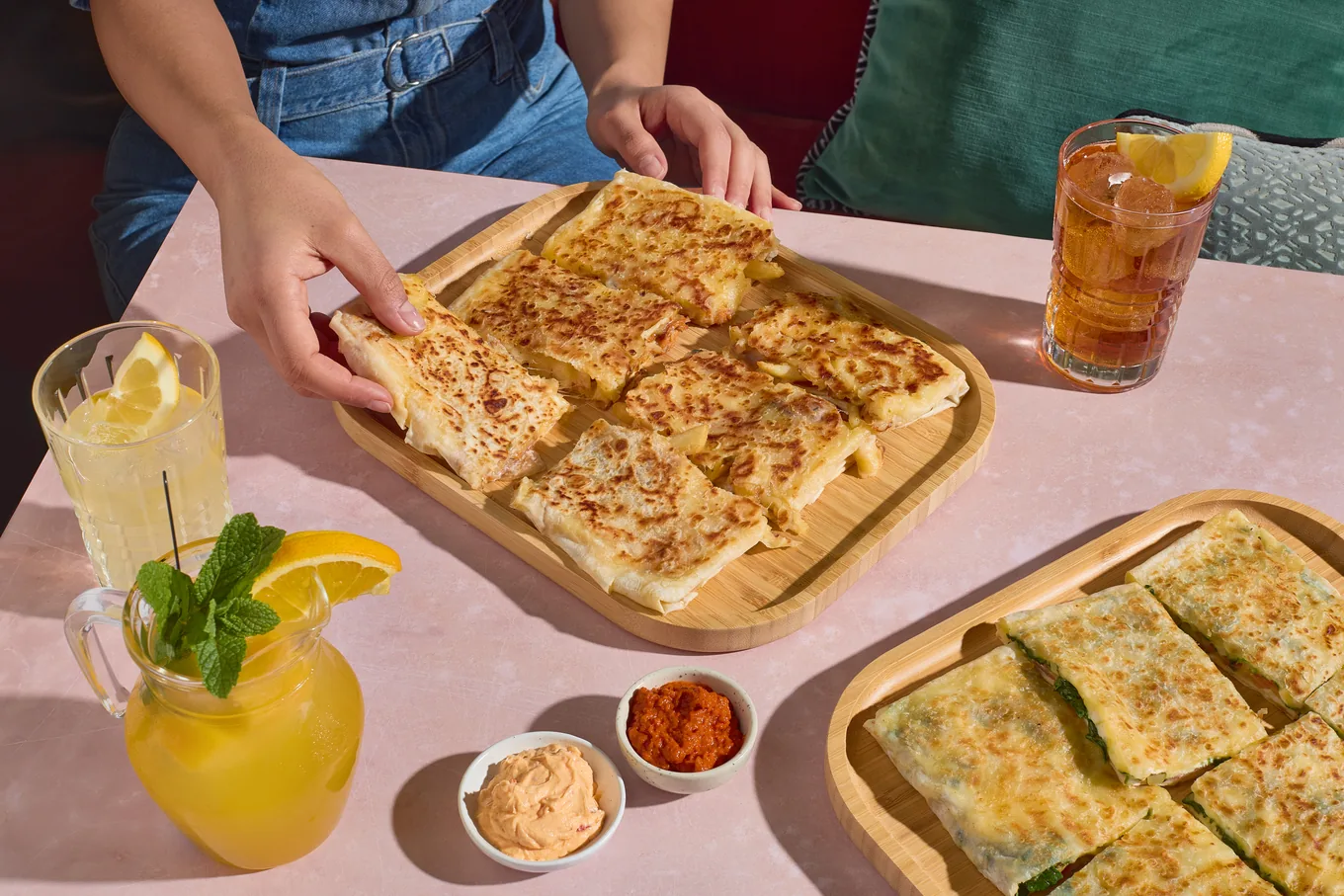 Vers gebakken gözleme op houten planken, met huisgemaakte limonade en ijsthee