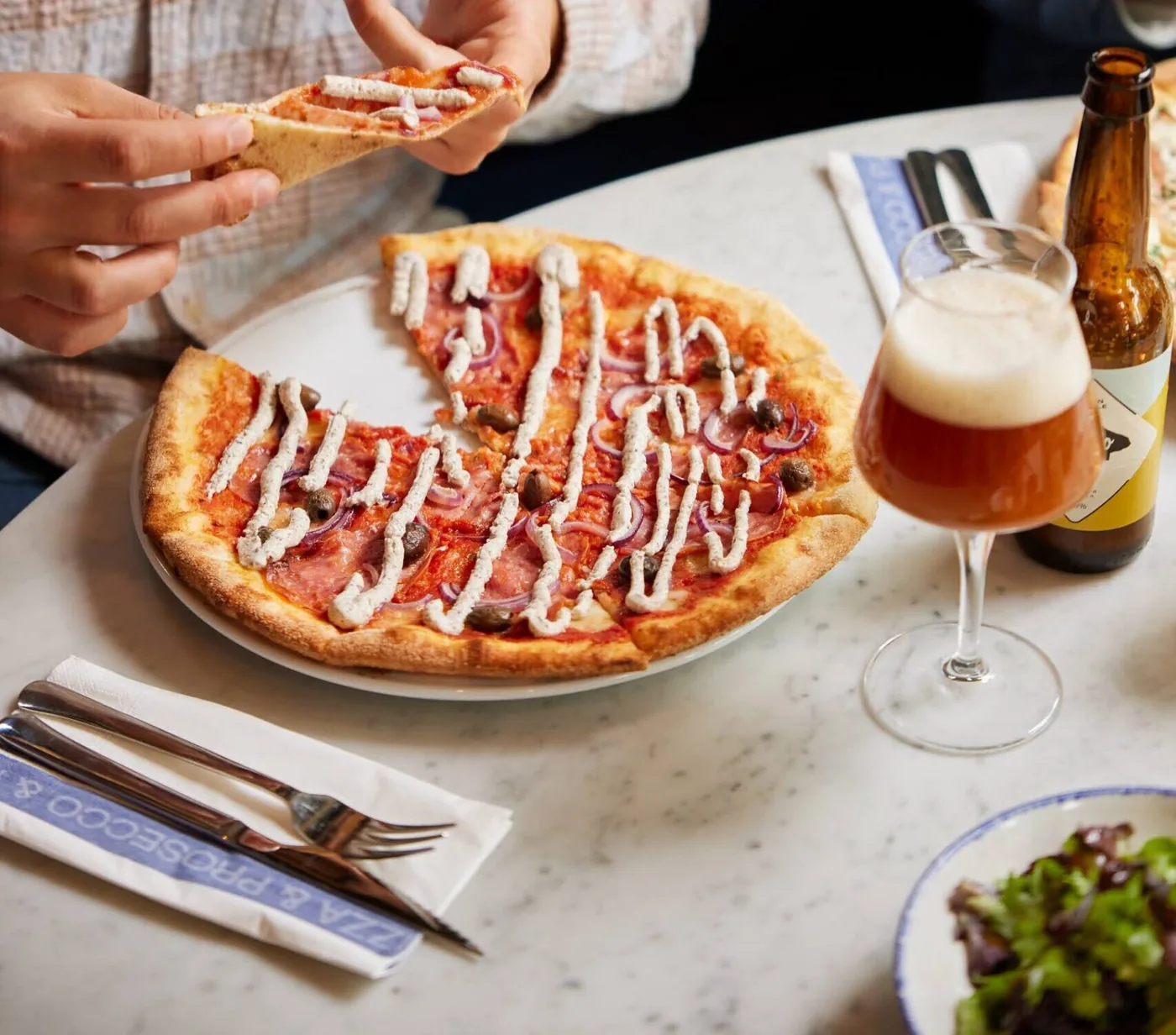 Pizza met een biertje erbij bij De Pizzabakkers