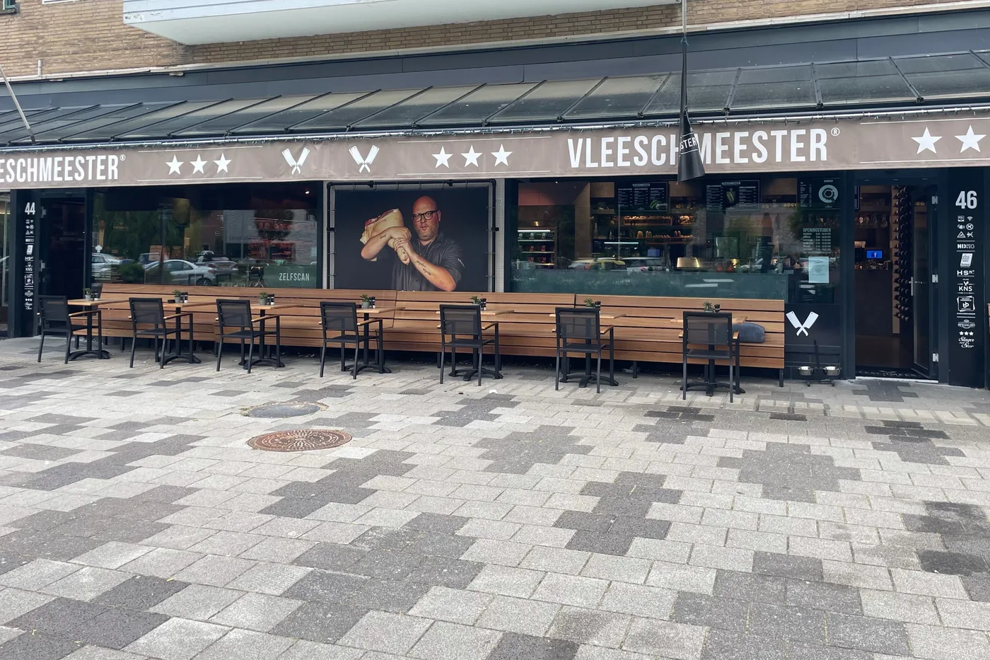 De gevel van een Vleeschmeester-vestiging met terras